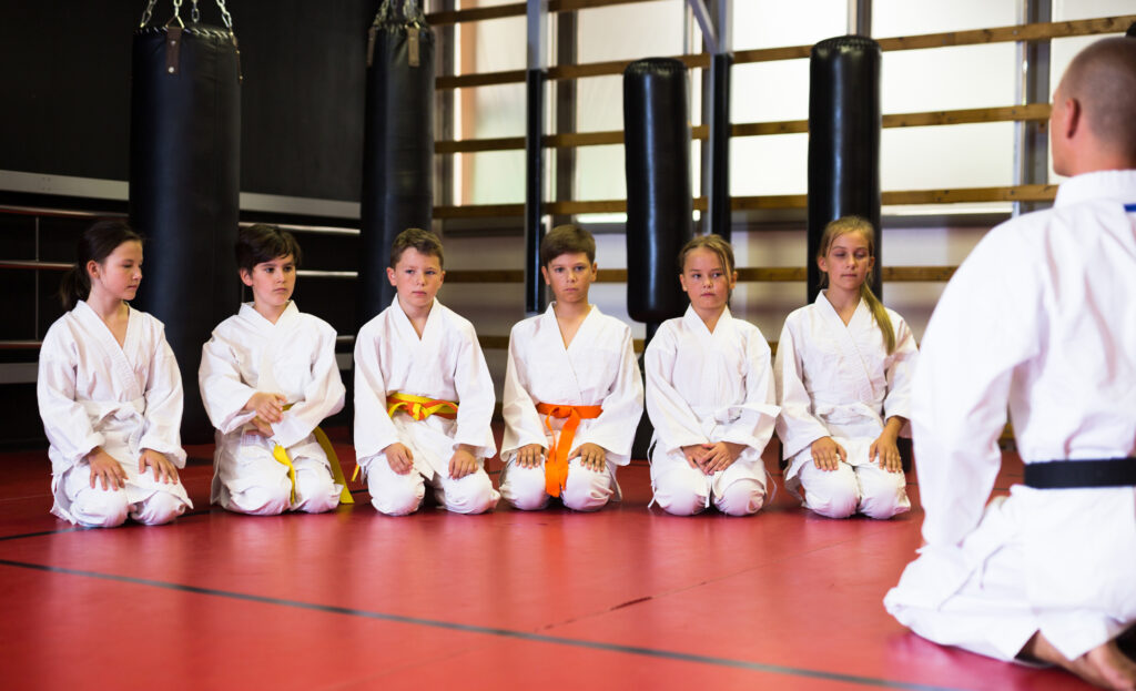 Group of martial arts students listening to teacher